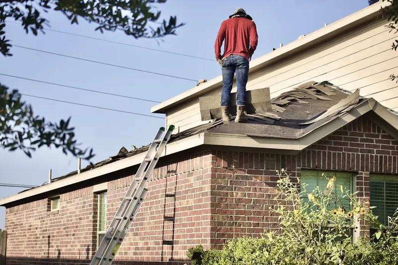Professional roofer working on a residential roof in Harris Hill